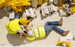 Man Laying on Floor with Coworker Helping Him with OSHA Fall Protection Training